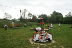 Zdjęcie: Zdjęcie przedstawia bawiące się dzieci na karuzeli. 